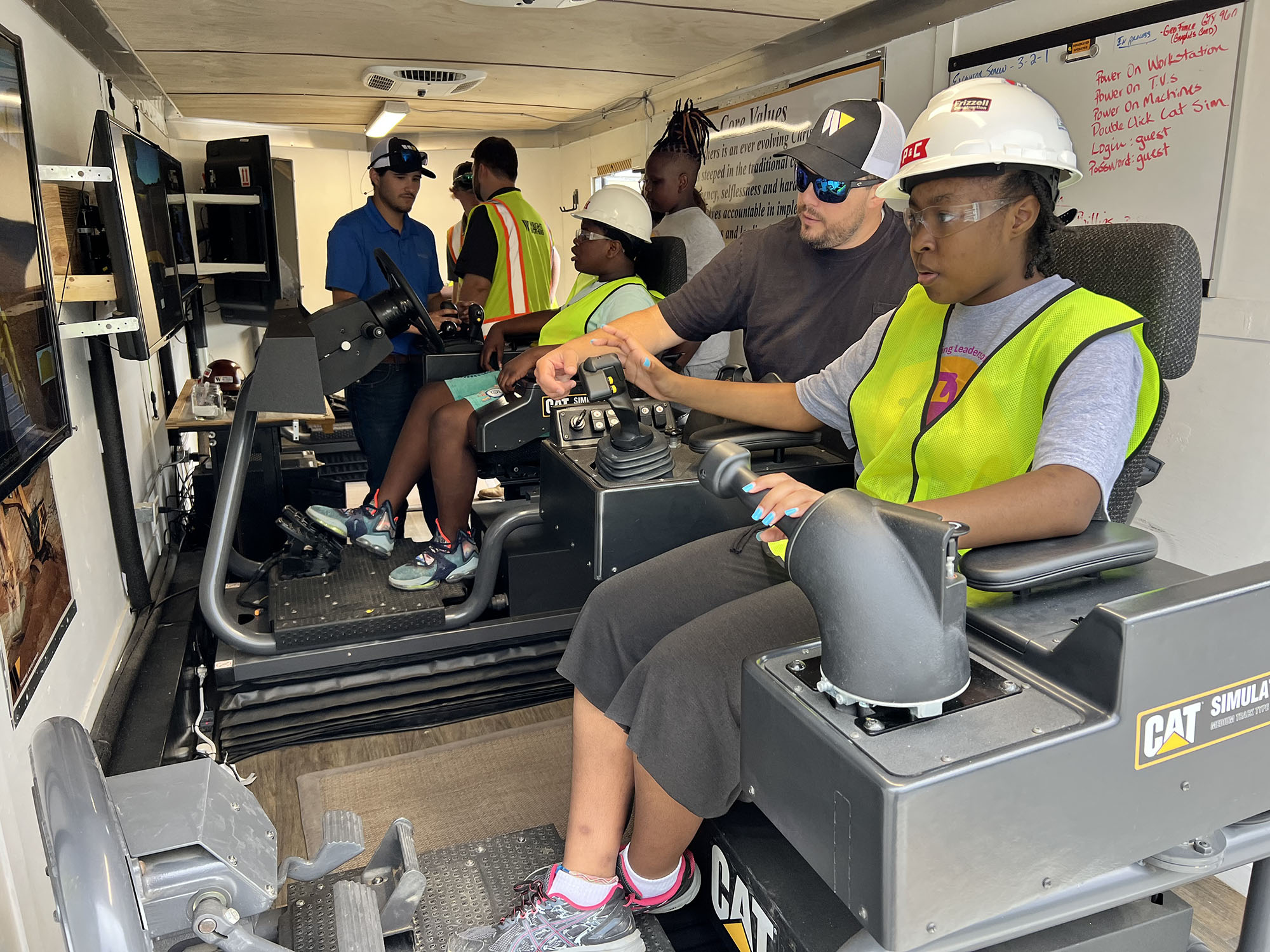 People wearing safety gear operating machinery indoors. People wearing safety gear operating machinery indoors.