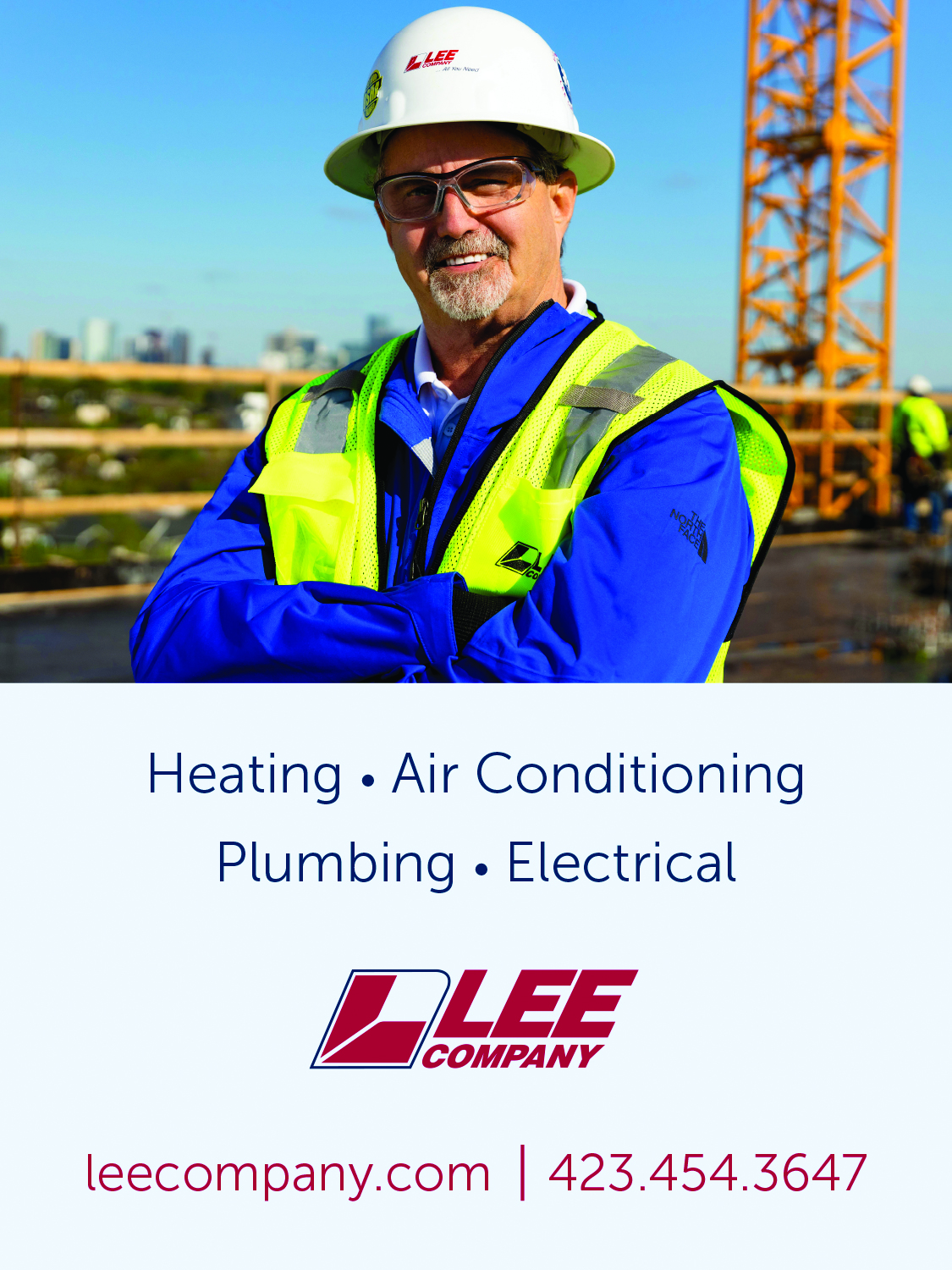 Smiling worker in safety vest at construction site for HVAC and plumbing services.